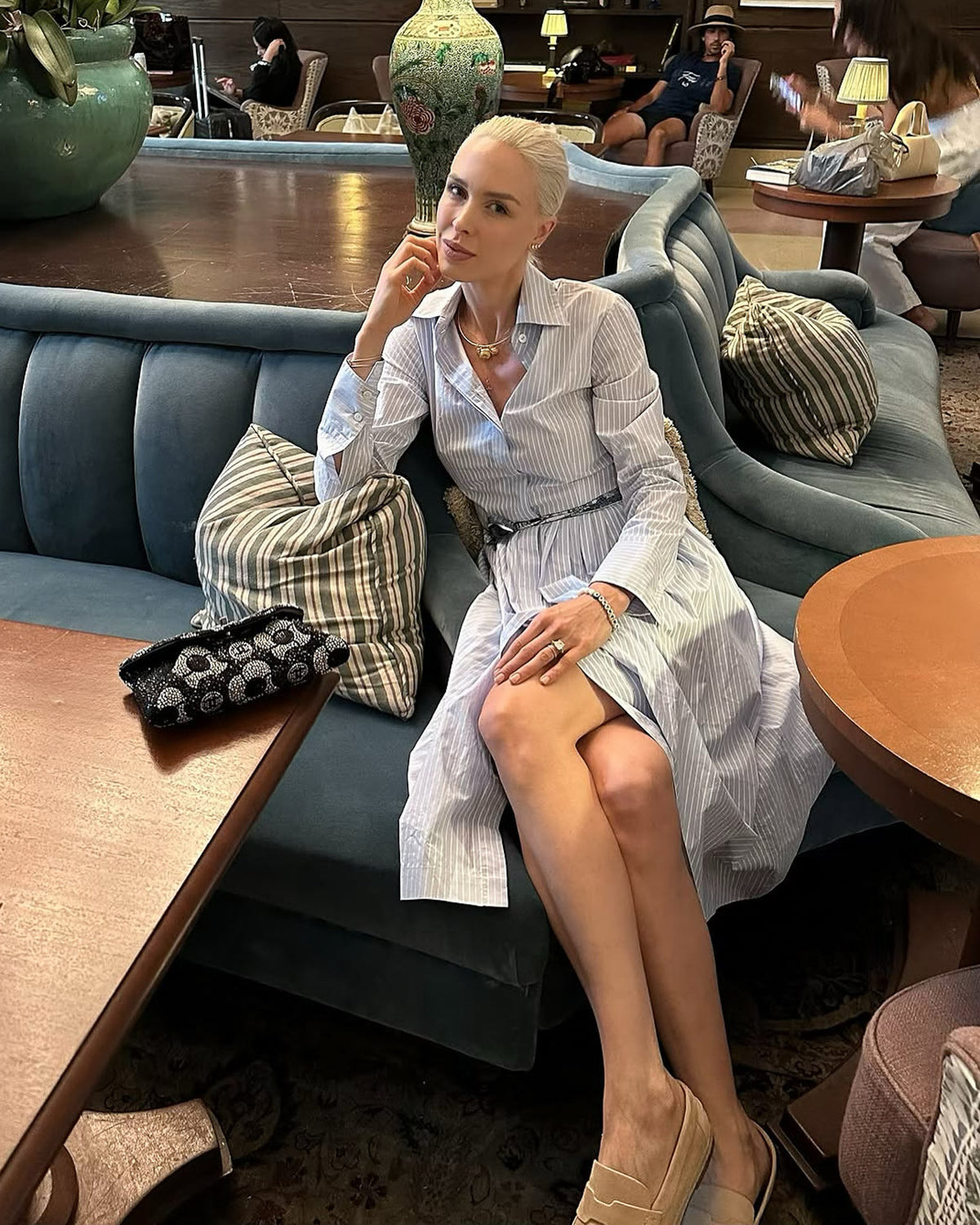woman in hotel lobby in blue shirtdress by Room502