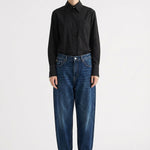 Person wearing a black shirt and blue jeans on a white background