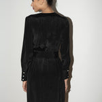 Woman wearing a black silk dress against a white background