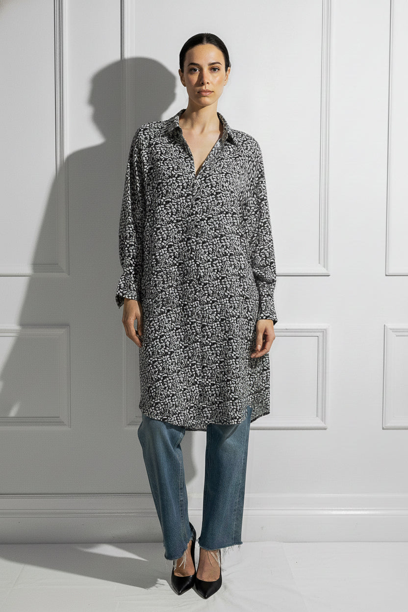 Woman on a white wall wearing a printed black and white Caftan by Room 502