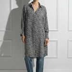 Woman on a white wall wearing a printed black and white Caftan by Room 502