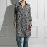 Woman on a white wall wearing a printed black and white Caftan by Room 502