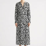 Woman wearing a black and white patterned dress by Room 502 on a white background