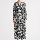 Woman wearing a black and white patterned dress by Room 502 on a white background