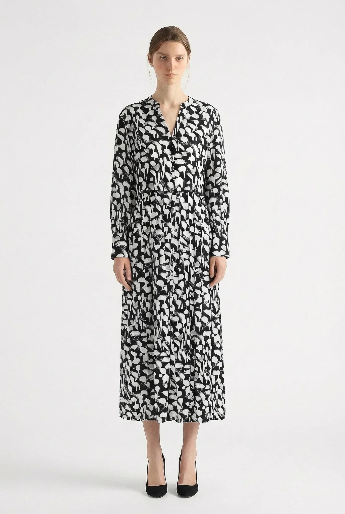 Woman wearing a black and white patterned dress by Room 502 on a white background