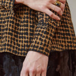Close-up of hands wearing rings, one with a leopard print sleeve.